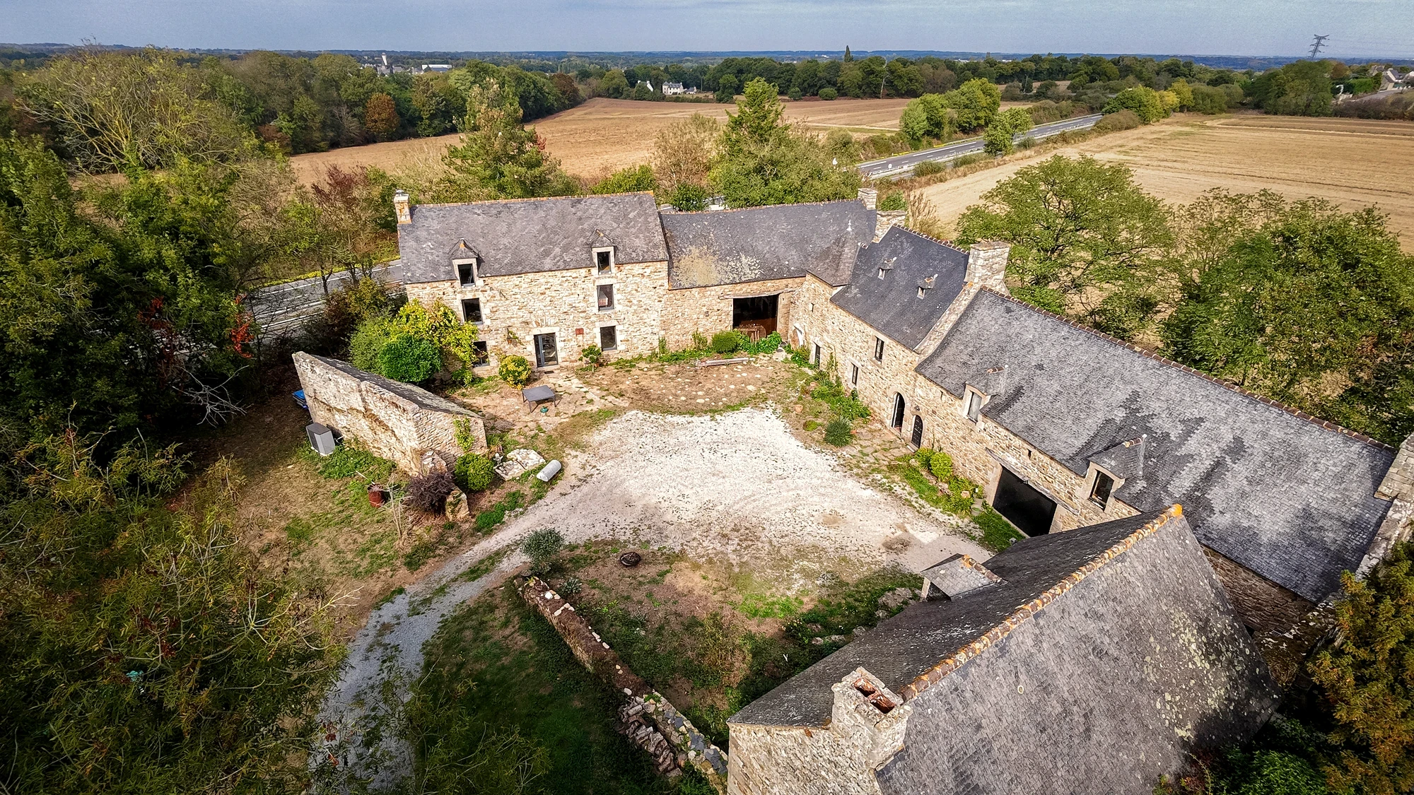 Vue de drone d’un corps de ferme en pierre et de sa cour