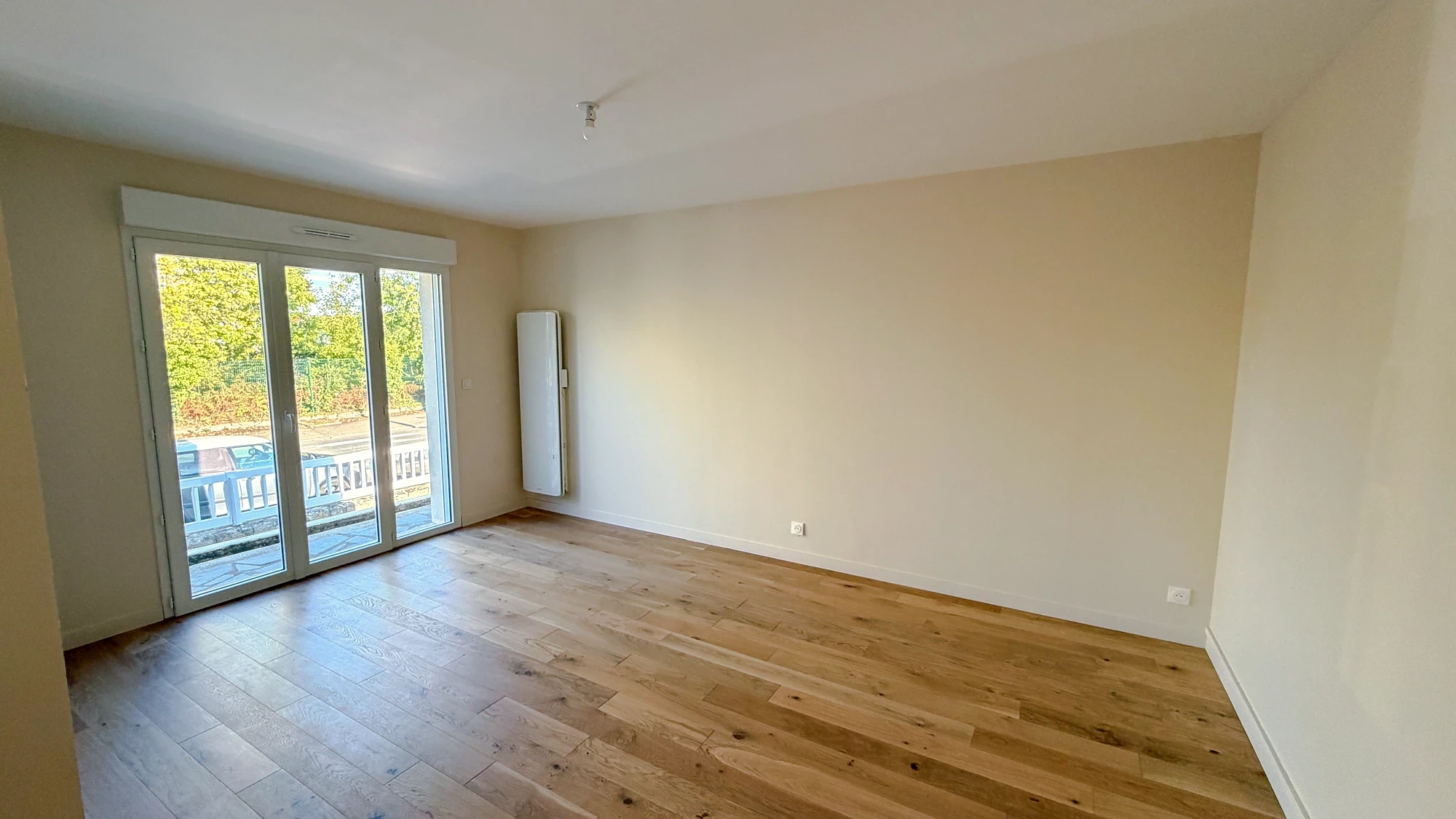 Séjour lumineux avec parquet et baie vitrée